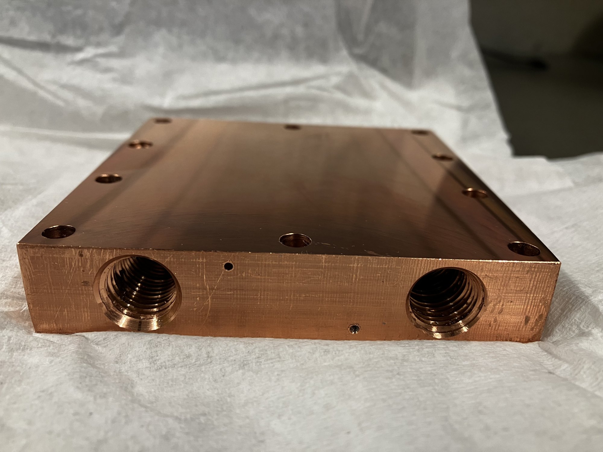 Machined C110 copper condenser block with 1/4 NPT ports, thermocouple holes and bolt pattern